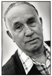 401936 Portret van marktkoopman Piet Meninga uit Hilversum die een marktkraam heeft met strips, lectuur en seksblaadjes ...